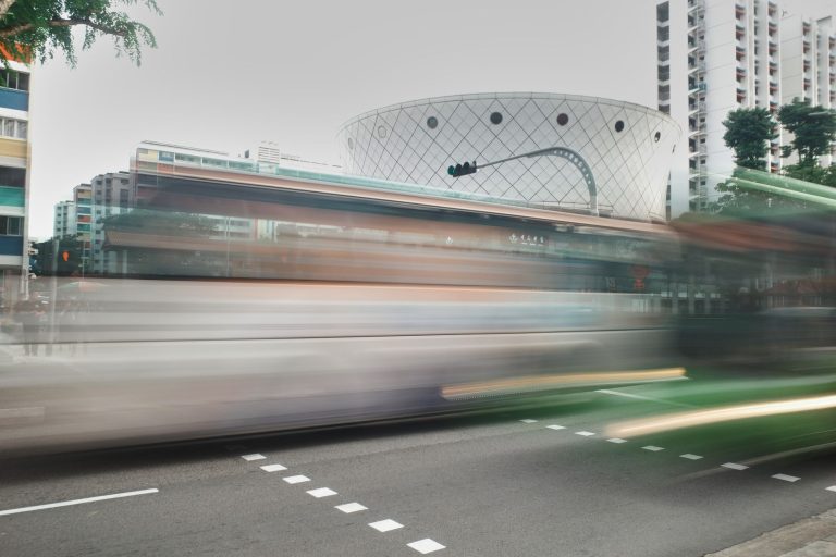 Nova central da Prefeitura passa a acompanhar ônibus do Rio em tempo real Ônibus urbanos circulam por uma via movimentada em meio a edifícios da cidade.